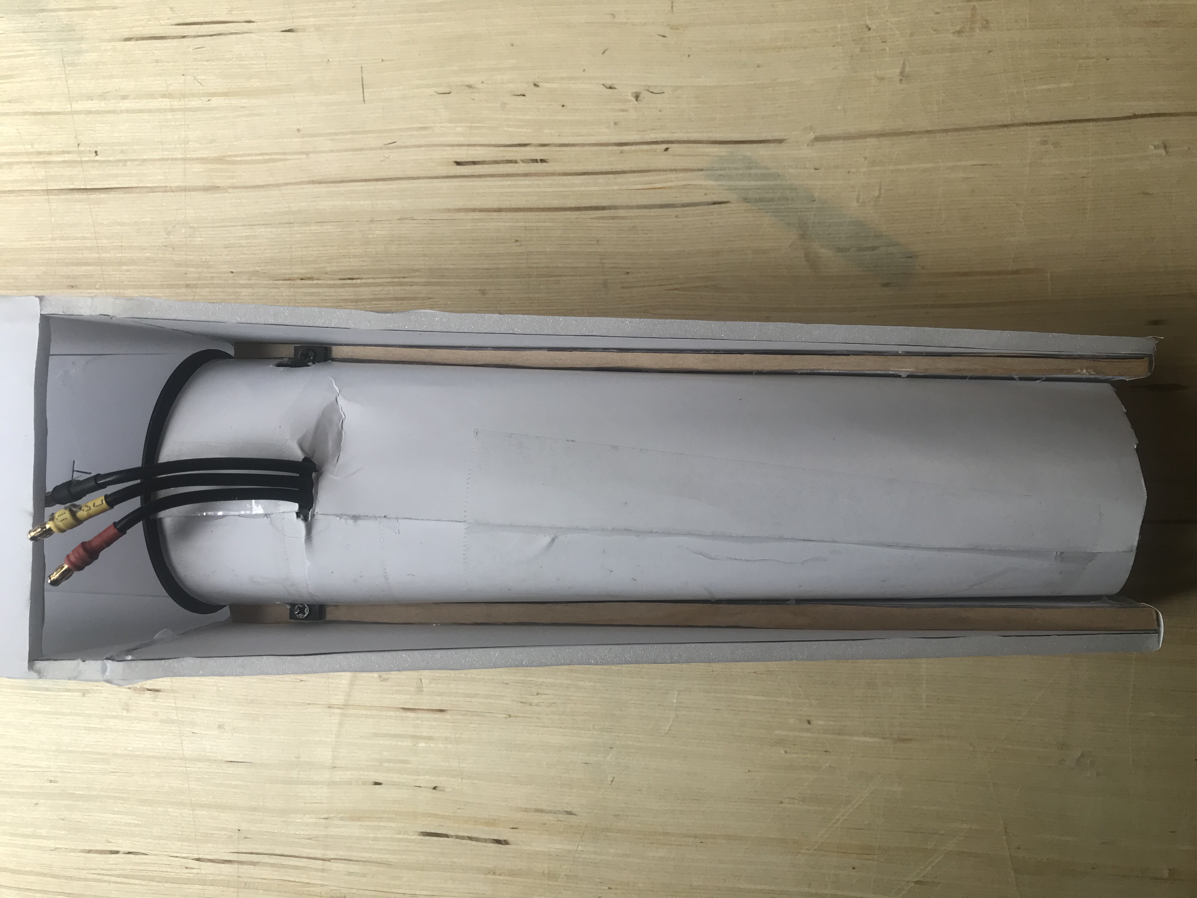 A 64 millimeter EDF is partially installed in a foamboard fuselage. Installed is a thrust tube made of poster board.